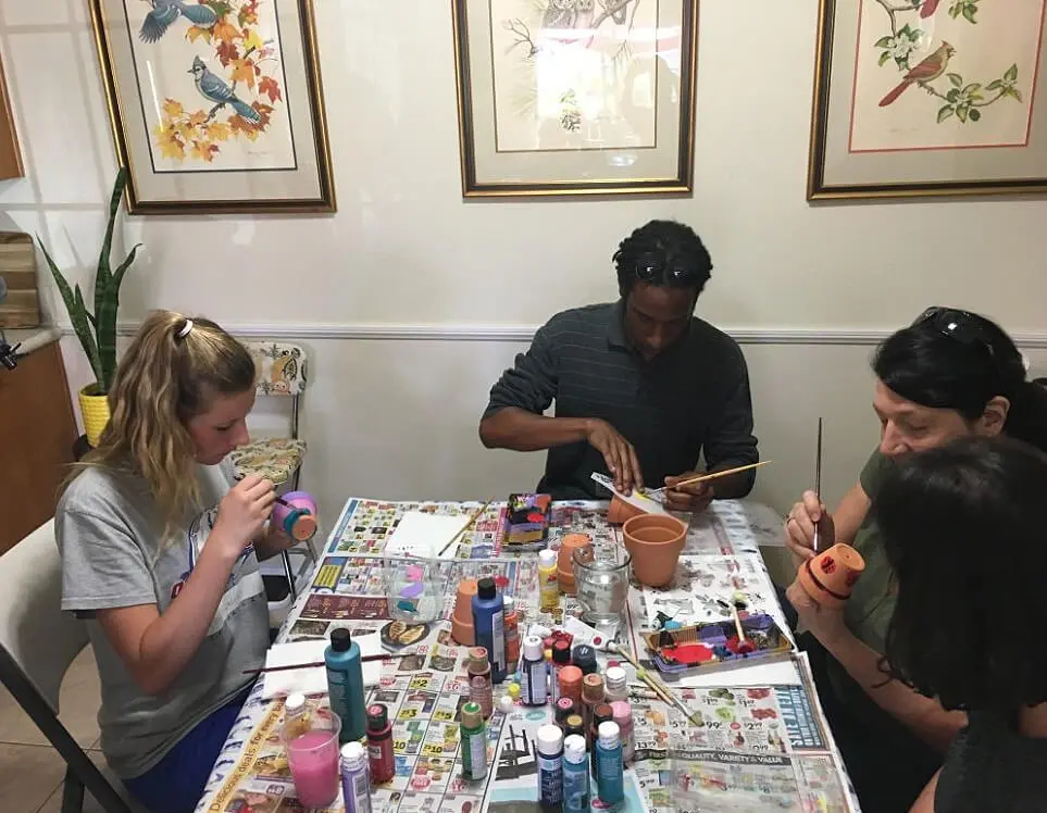 A group of people sitting around a table with paint.